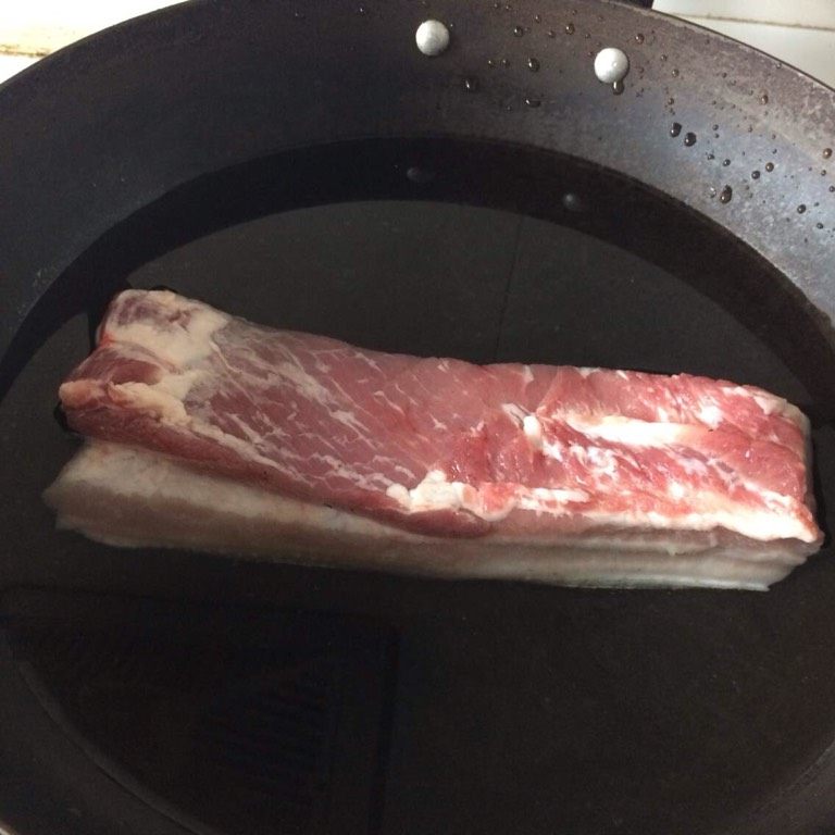 秘制红烧肉,2、用火稍微把肉皮烧一下,既可以去毛,也可以让烧出来的肉更香。3、抄水,加少许盐,水开后去除血末。