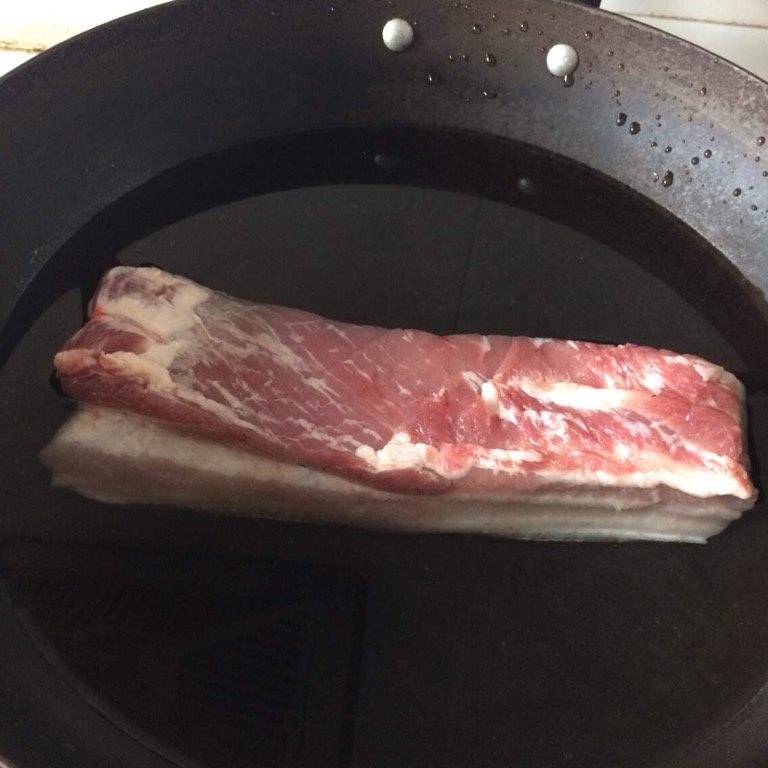 秘制红烧肉,2、用火稍微把肉皮烧一下，既可以去毛，也可以让烧出来的肉更香。3、抄水，加少许盐，水开后去除血末。