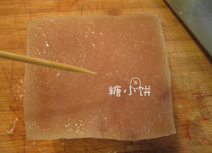广式脆皮烧肉,用牙签在肉皮那一面扎上细密的孔,再抹上小苏打,小苏打全部都抹在肉皮这一面