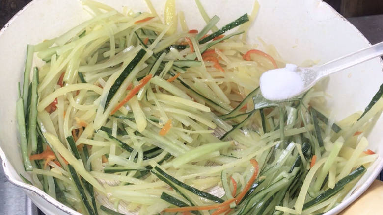 黄瓜炒土豆丝,加盐,翻炒均匀至入味