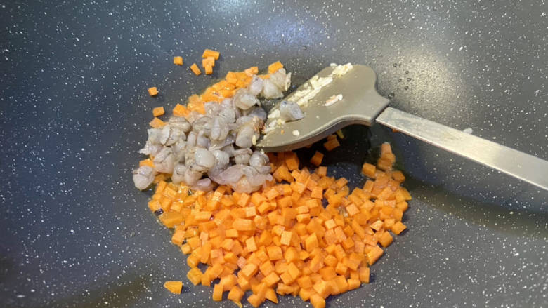 玉米虾仁蛋炒饭,再加少许食用油，油温热，下虾仁胡萝卜粒，中火煸炒虾仁变色