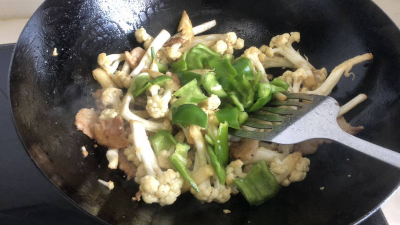 青椒炒花菜,最后放入青椒,加盐、糖调味,翻炒均匀入味即可