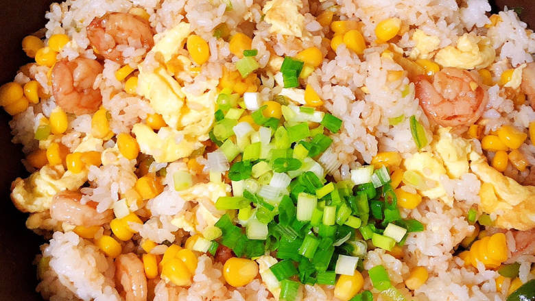 玉米虾仁蛋炒饭,撒上香葱,翻炒入味,即可出锅了。