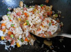 黑胡椒蘑菇培根焗饭,锅内放油烧热,加入材料炒熟,再加入米饭,炒匀