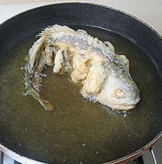 糖醋黄鱼,待鱼定型后,将鱼翻过来。将鱼炸制金黄色盛出。待油锅升温后再复炸一下