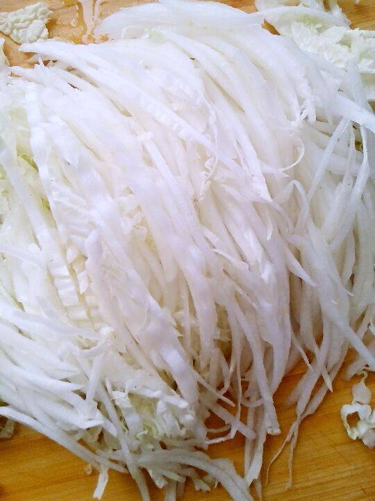 自制腌酸菜,将白菜洗后,白菜叶先片成两片到三片后,切成丝备用。