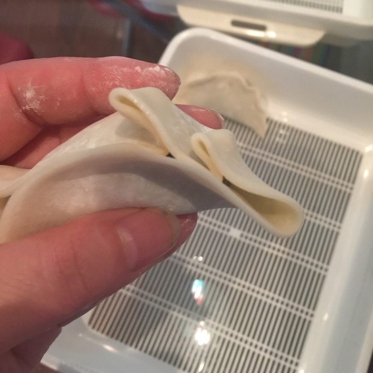 牛肉芹菜饺子,如图先在右侧打2个褶子捏紧;