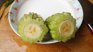 苦瓜酿香蕉,煮至苦瓜颜色深绿捞出，香蕉切成两断塞进煮好的苦瓜内，切片摆盘即可