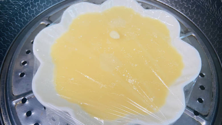 蟹棒蒸蛋,盖上保鲜膜,用牙签扎几个小洞。上锅蒸6分钟