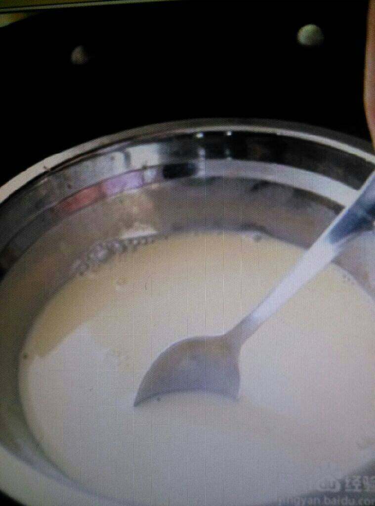 鸡蛋牛奶布丁,将上一步的碗放入热水里,不停的搅拌,让QQ糖慢慢的融化,用的葡萄味的QQ糖,所以做出的布丁还有葡萄味的味道。