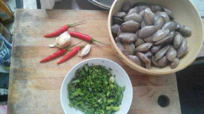 爆炒蛤蜊,蒜苗香菜剁末。辣椒和蒜切片,蛤仔洗干净