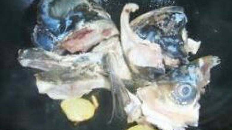 鱼头豆腐汤,不粘锅中倒入油，待七成热时放入鱼头，用中火双面煎黄（每面约煎3分钟）