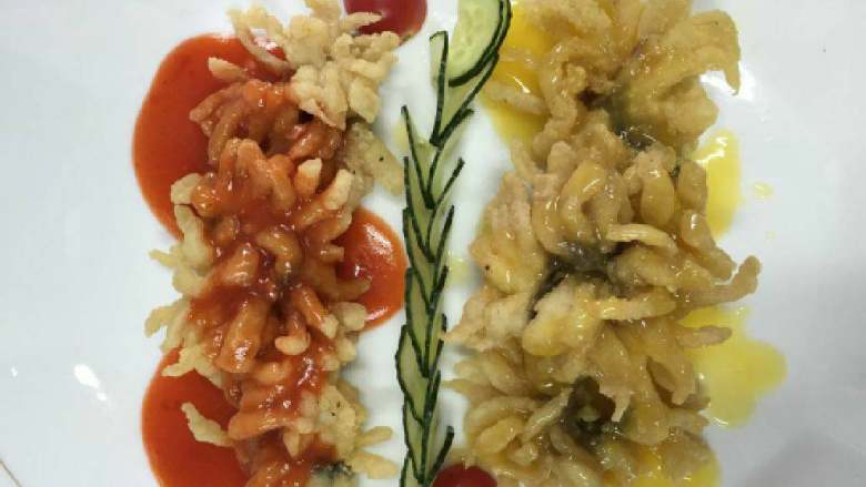 双色菊花鱼,将<a style='color:red;display:inline-block;' href='/shicai/ 397'>草鱼</a>宰杀处理干净，从鱼头后端切入，再顺着鱼背部一点一点地将<a style='color:red;display:inline-block;' href='/shicai/ 397'>草鱼</a>两侧的鱼柳片下来。
番茄洗净，将内芯剔出剁碎，再将番茄肉切成0.5cm见方的小丁。香葱洗净切碎。
将鱼柳上横向斜刀切成0.5cm宽的片，注意不要将鱼皮切断，使每片鱼片间只有鱼皮相连，以每5片鱼片为一组，将鱼皮切断。
接着在每5片为一组的鱼片上纵向垂直下刀，每刀间隔依然为0.5cm，将每组鱼片全部切成菊花瓣状。
在切好的鱼肉中调入盐（1/2茶匙，3g）、白胡椒粉和绍酒，混合均匀后腌制10
分钟。
将泡打粉均匀地混入干淀粉中，再将腌好的鱼肉放入，均匀地蘸上一层干淀粉。
中火烧热炒锅中的油，待烧至六成热时（将手掌置于炒锅上端，能感到有明显的热气升腾），将鱼肉放入，用大火炸制约3分钟，待鱼肉表面绽开呈金黄色菊花形，再捞出沥干油分摆入盘中。
锅中留底油，烧热后将番茄芯碎放入翻炒片刻，随后放入番茄沙司、白砂糖、盐（1/2茶匙，2g）和少许