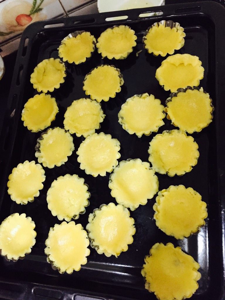 可可奶油水果塔,塔皮部分:黄油软化后和低粉揉搓成粉状加入蛋黄、盐和糖,揉成团,盖上保鲜膜放入冰箱冷藏30分钟。用擀面杖擀成薄片,用塔模印出一个个形状后用叉子叉出小孔,放入冰箱冷藏。