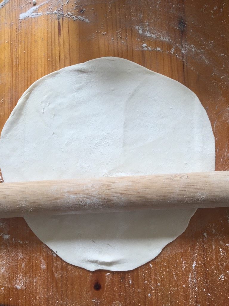 手擀面条,把面团揉成一个圆,然后用擀面杖擀成饼状,这时候在撒上面粉,继续擀,擀到差不多薄