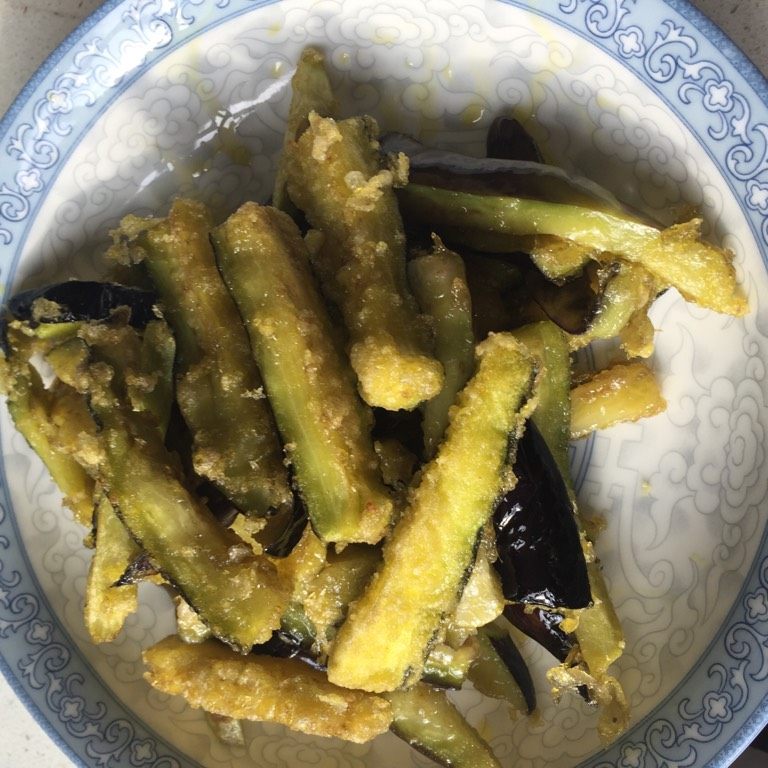 咸鱼茄子煲,茄子洒上少许淀粉，但要尽量让每一条茄白都有淀粉，然后用热油稍微炸一下，微微发黄即捞起备用。