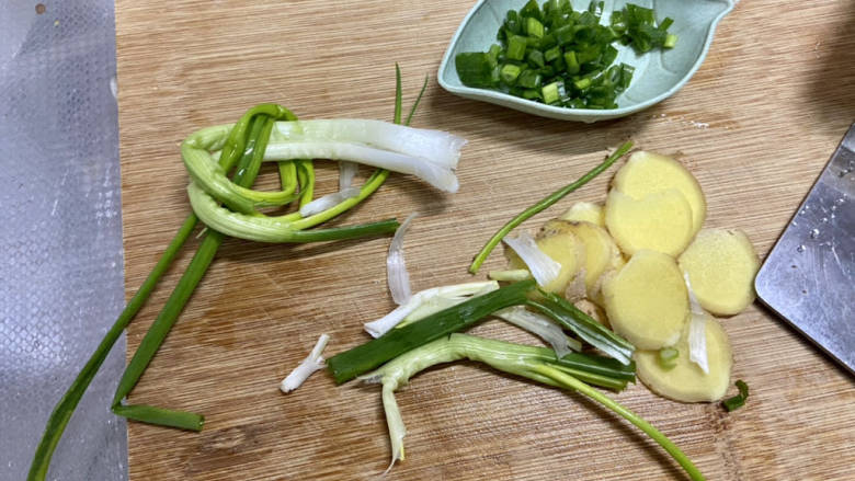 鲫鱼豆腐菇菌汤,小葱洗净,两根绑葱结,一根揉搓,姜搓洗干净切片,再切点葱末