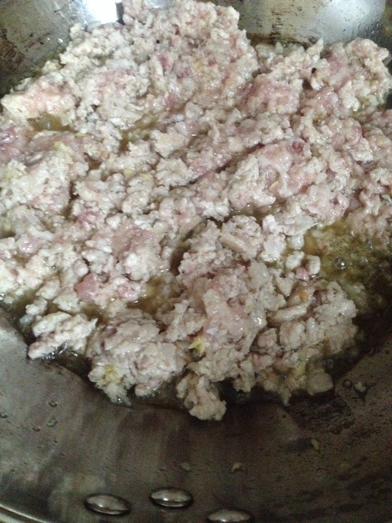 猪肉豇豆大葱包子,热锅倒油,油热后放入猪肉末翻炒,加入姜末一起翻炒