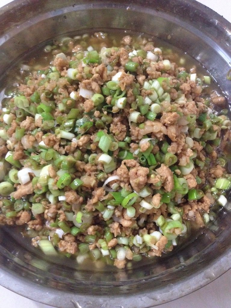猪肉豇豆大葱包子,盛入盆中,冷却后放入冰箱冷冻室,冷冻一小时