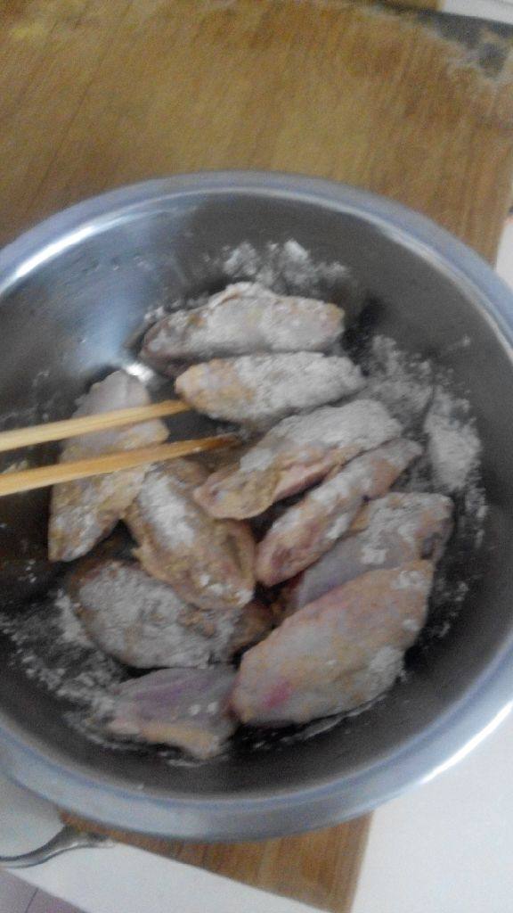 炸鸡翅,把腌制调料倒在鸡翅中上,再加入一点清水搅拌均匀,腌制20分钟