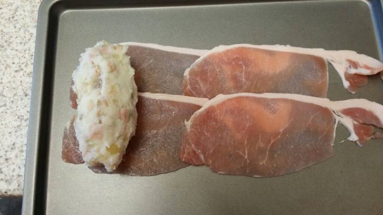 土豆培根烤肉,找一个盘,先排列好培根条,放入土豆后,把培根盖在土豆上,这样就轻松地用培根把土豆包裹起来了
