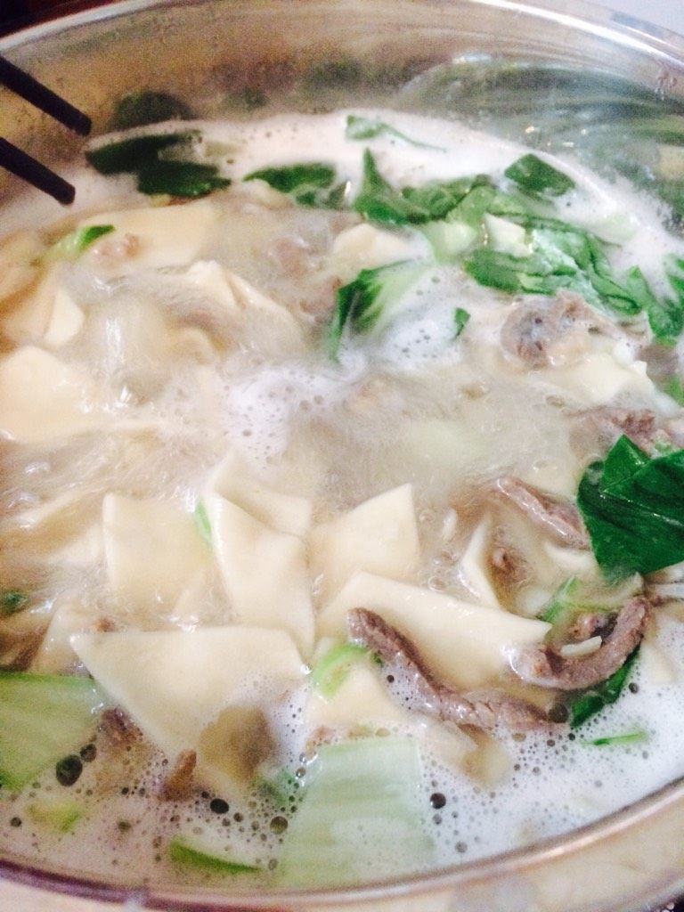 羊肉汆面片儿,羊肉变色,沸腾加入青菜,煮沸即可关火