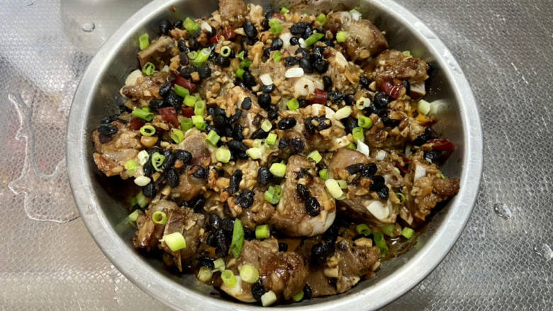 蒜蓉豆豉蒸排骨,取出,去除保鲜膜,撒葱末即可上桌享用