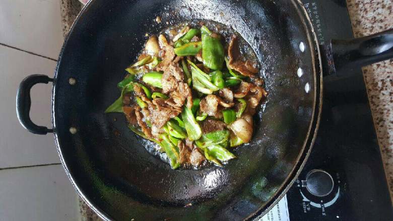 妈妈拿手菜——回锅肉,翻炒5-8分钟,让肉和青椒上色,熟透。