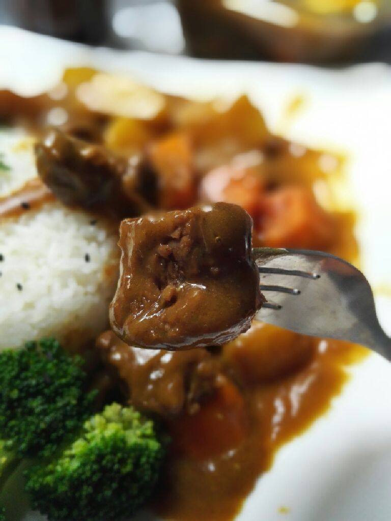 咖喱牛肉饭,把米饭放入碗中压实,倒扣在盘子。浇上咖喱牛肉即可。
