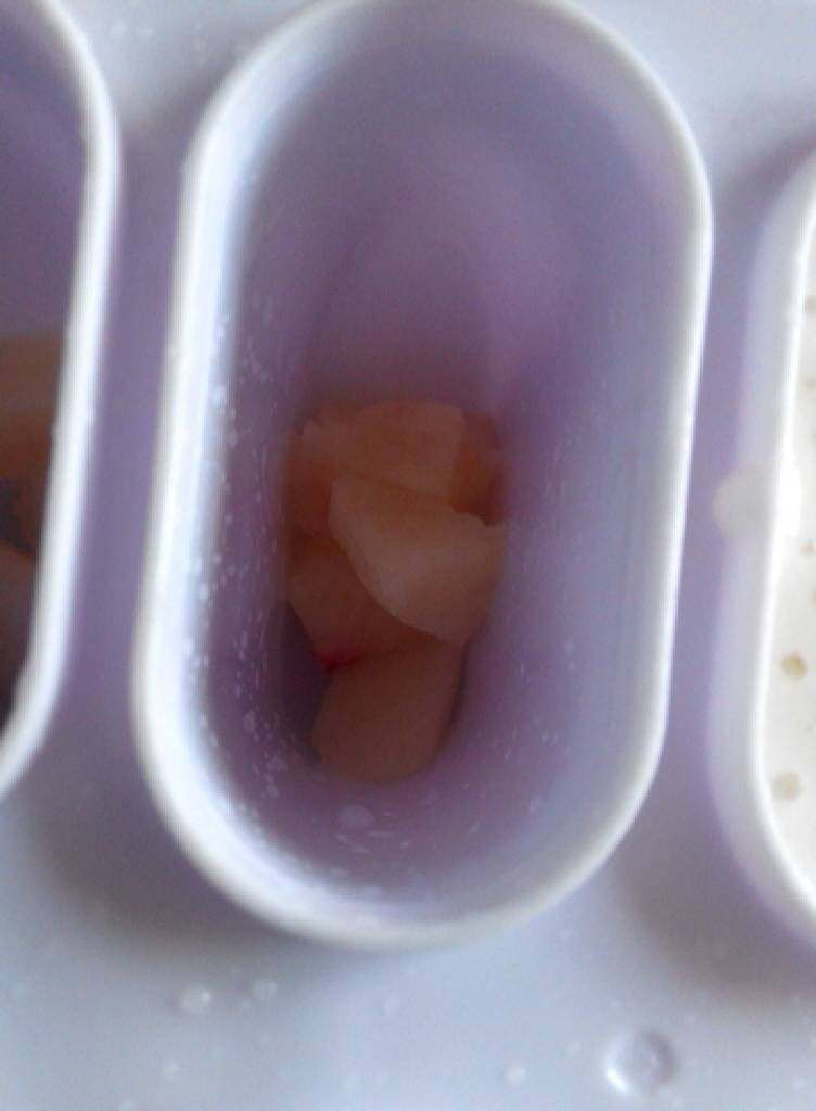 蜜桃酸奶冰棒,准备好冰棒模具,加少许桃子块,再倒入桃子酸奶糊