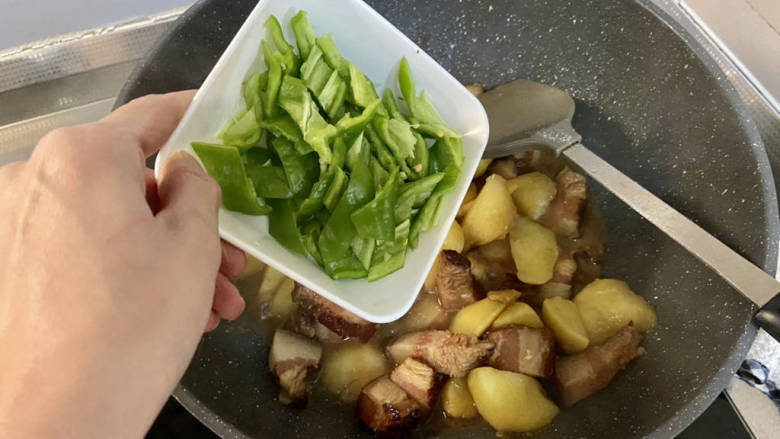 红烧猪肥肉➕土豆烧肥腊肉,汁收的差不多,下青椒,中火翻炒断生炒出辣椒辣香味