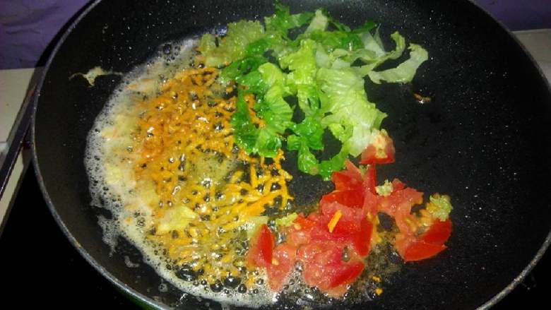 宝宝铺食 蔬菜牛奶滑蛋,锅里放少量油,倒入生菜胡萝卜番茄倒入