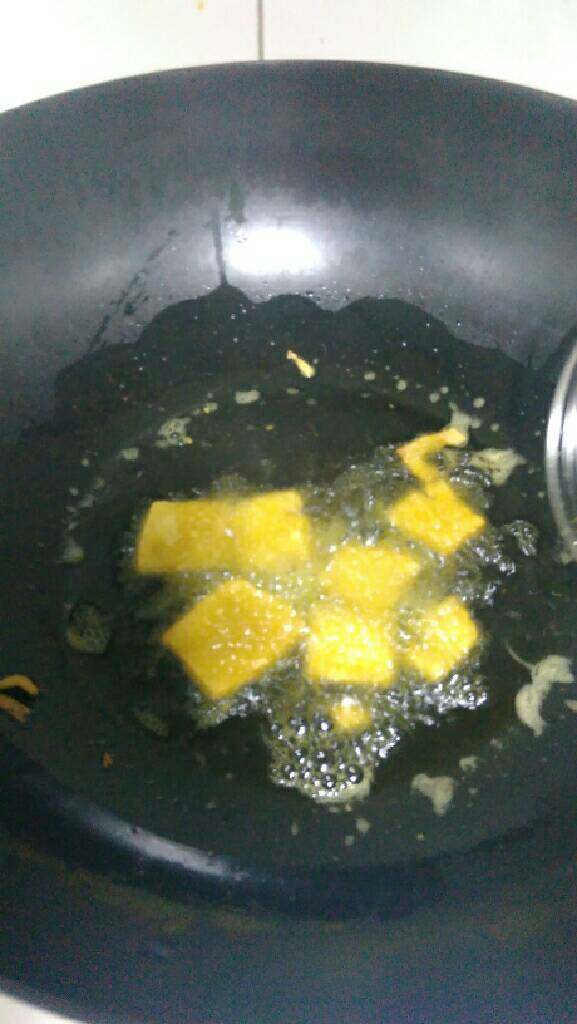 自制炸臭豆腐,待油锅中的油热到八成热时，放入适量豆腐，炸至起把泡。
