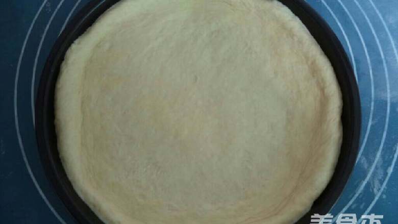 自制披萨,将面片放入披萨盘内,用手按压成四周厚中间薄的饼底