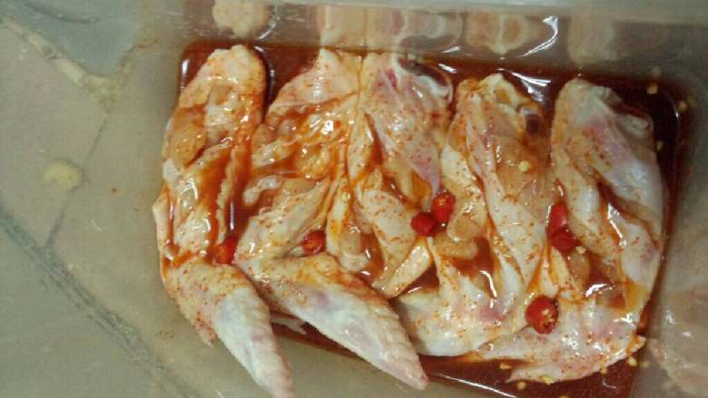 奥尔良烤翅,在将鸡翅摆好在盒子里，在倒入一半的奥尔良水