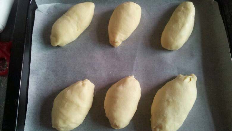 牛奶面包,取出排气，分成6等份滚圆，静置10分钟，整型成椭圆形，二次发酵至2倍大