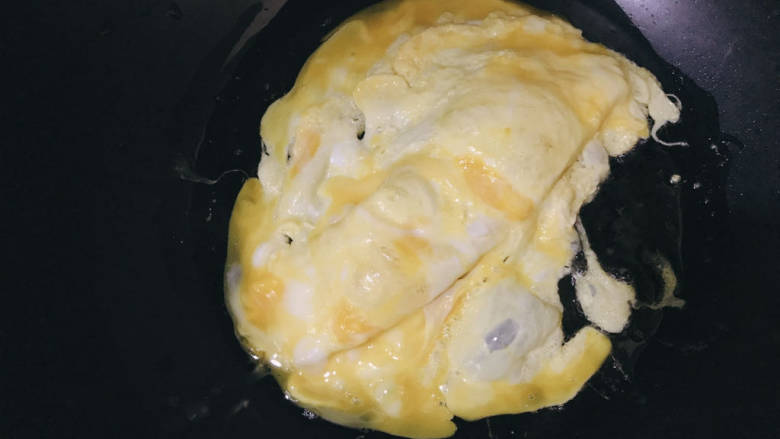 火腿青菜炒鸡蛋,锅中热油,加入蛋液,小火煎至凝固