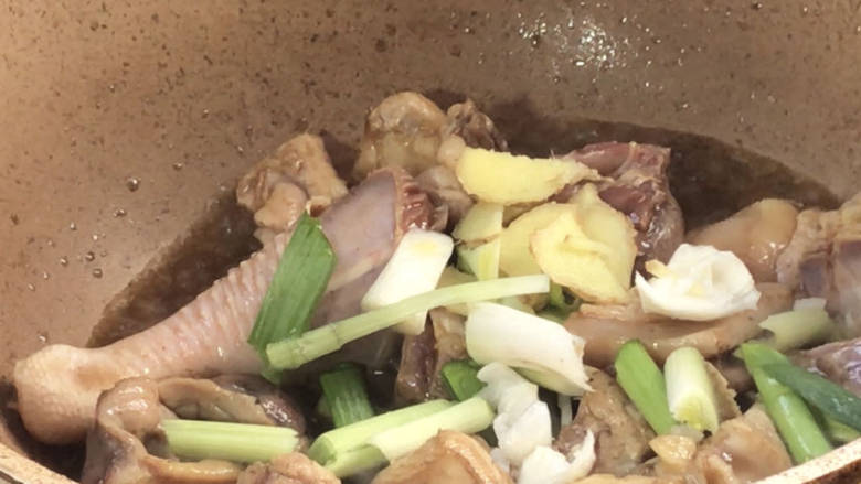 山药焖鸡,放入姜末和青蒜梗,炒香