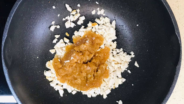 煎酿豆腐,锅里加油,烧热,加入剩余的豆腐碎和肉泥