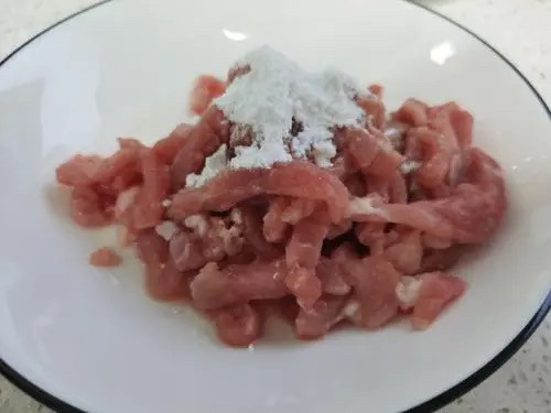 京葱炒肉丝,将料酒倒入肉丝中一勺拌匀,再倒入一点点<a style='color:red;display:inline-block;' href='/shicai/ 788'>生抽</a>拌匀,最后放点淀粉拌匀。