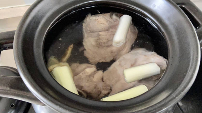 胡萝卜筒骨汤,取一个深砂锅或者珐琅锅等汤锅,加入适量清水(我加了大概3升),加入焯水洗净的筒骨,剩下的姜片,葱段,