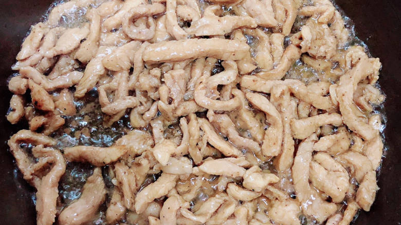 千张肉丝,锅中倒入油,加热至五成热,放入肉丝翻炒均匀。