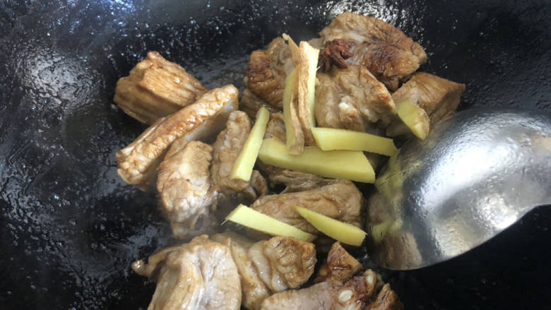 白萝卜炖猪肉,倒入排骨翻炒,把排骨炒香,加入姜丝和料酒继续翻炒。