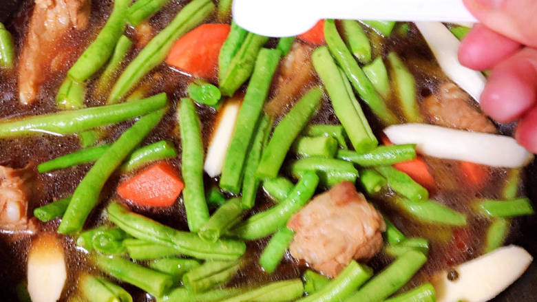 豆角焖卷子,加入蔬菜,加入盐,继续炖煮。