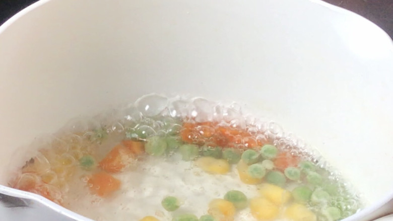 香炸锅巴肉,起锅烧开水,放入三色蔬菜丁煮断生