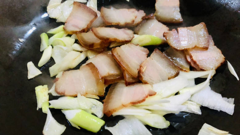 豆干炒腊肉,锅中倒入少许食用油,放入葱花、腊肉炒香。