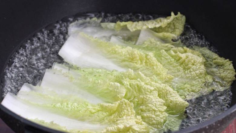 白菜卷肉,白菜叶前面根部位置切掉,放进沸水中烫软,捞出过凉水挤去多余水分。