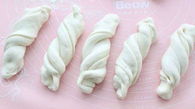 排骨土豆炖豆角,切成宽度一致的面剂子,提起面剂子的两头稍微抻长,两手再分别反方向拧成麻花状,覆盖保鲜膜醒发。