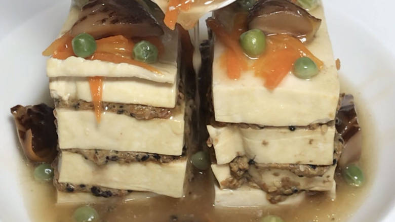 芝香豆腐,取出蒸好的豆腐,摆入盘中,浇入煮好的汤