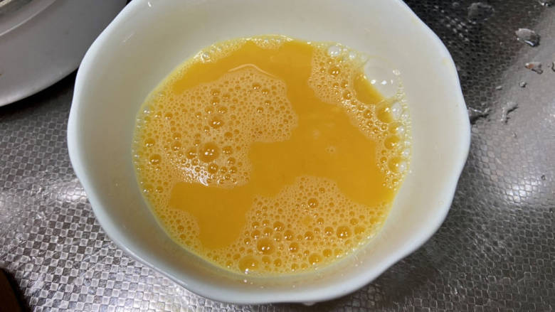 番茄黄瓜炒蛋,鸡蛋打入碗中加少许食盐,搅打成均匀蛋液